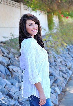 Brunette with a charming smile shows her flower after picking flowers