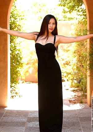 Brunette in fancy black dress showing her legs and teasing the camera